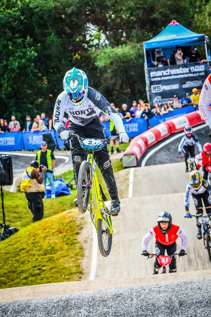Airborne in front of the crowd and the Manchester BMX tower at the 2026 British Championships